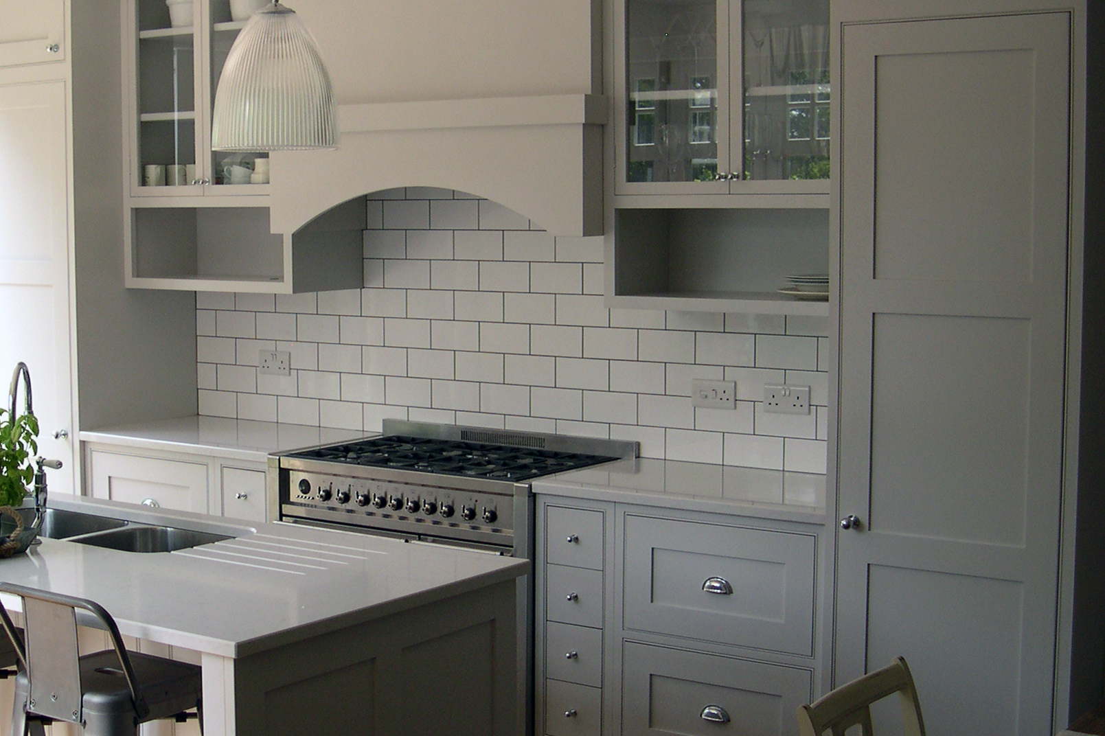 Bespoke kitchen in Lichfield Staffordshire with beaded frames, glazed wall cabinets either side of arched extractor housing