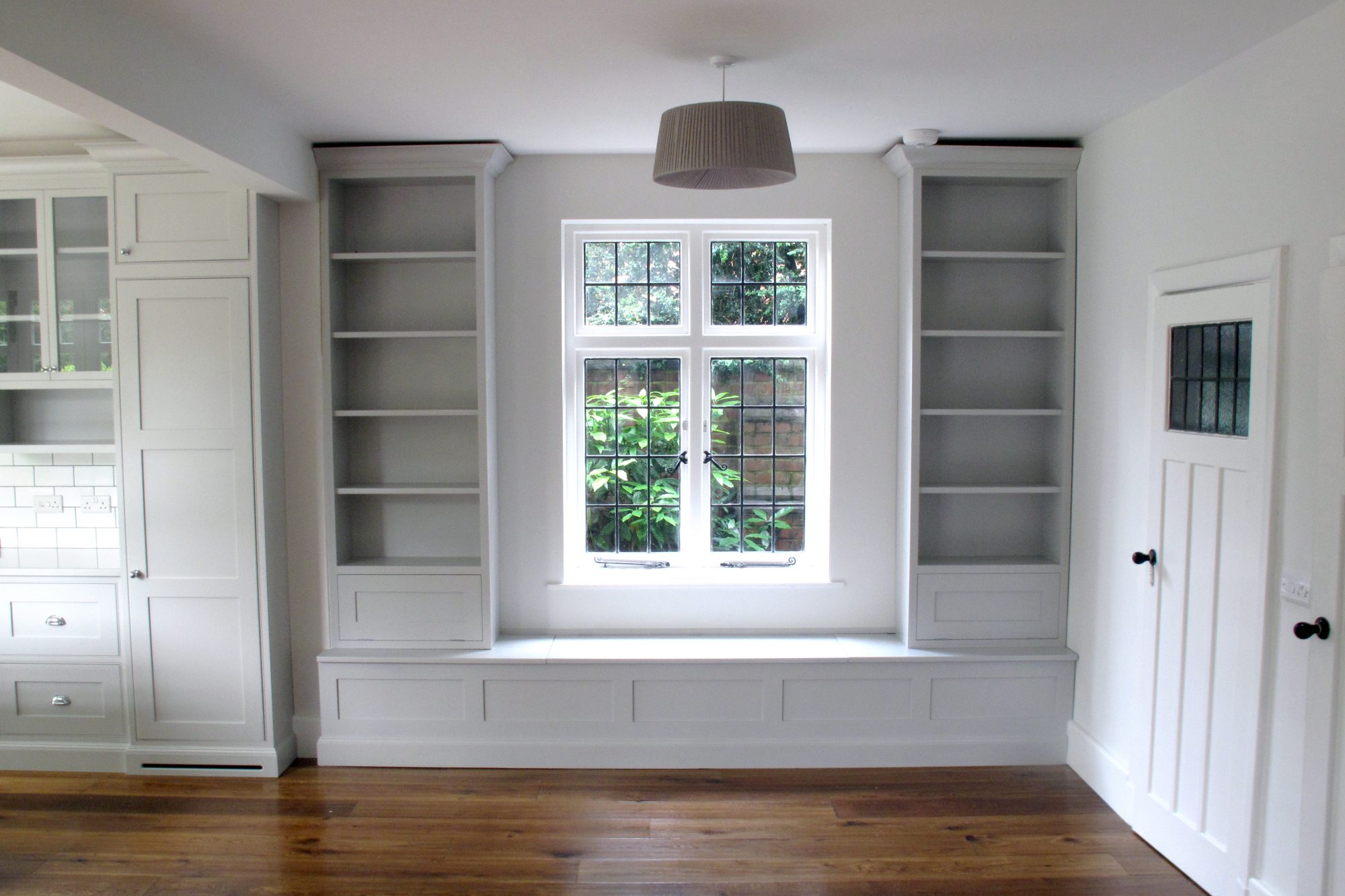 Tall book cases on top of long window bench seat