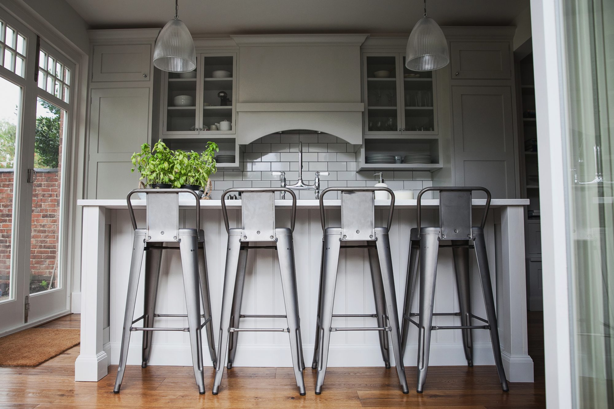 island with cutout seating area along the back , containing 4 stools, overlayed plinth detail.